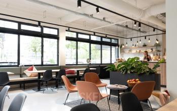 Moderne kantoorruimte met hoge ramen en comfortabele zitgelegenheid bij Hogehilweg 19, Amsterdam Zuid-Oost, ideaal voor huren.