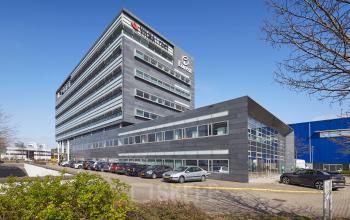 Exterieur van het kantoorpand op Laarderhoogtweg 7-19 in Amsterdam Zuid-Oost met geparkeerde auto's ervoor en duidelijke architectuur.