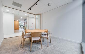 Stijlvolle vergaderruimte met houten tafel en zes stoelen in kantoorpand aan de Laarderhoogtweg 7-19 in Amsterdam Zuid-Oost.