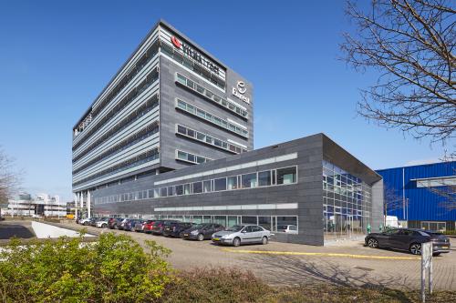 Exterieur van het kantoorpand op Laarderhoogtweg 7-19 in Amsterdam Zuid-Oost met geparkeerde auto's ervoor en duidelijke architectuur.