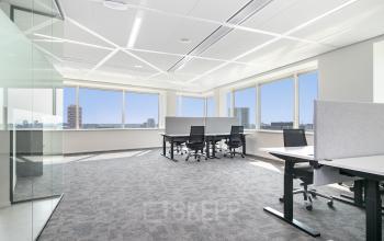 Ruime, lichte kantoorruimte in Amsterdam Zuid-Oost met grote ramen en moderne bureaus voor een productieve werkomgeving.