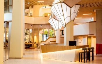 Lichte en moderne kantoorruimte met stijlvolle houten accenten op Bijlmerplein 888, Amsterdam Zuid-Oost, met een zitgedeelte en ontvangstbalie, ideaal voor kantoorruimte huren.