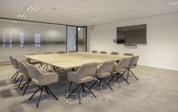 Vergaderruimte in kantoorpand aan Hogehilweg 24, Amsterdam Zuid-Oost met moderne houten tafel en comfortabele stoelen, ideaal voor kantoorruimte huren.
