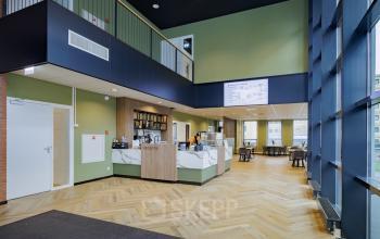 Modern kantoorinterieur op Hogehilweg 24, Amsterdam Zuid-Oost met lichte houten vloer, receptiebalie en ruime vergaderplekken. Ideaal voor bedrijven die kantoorruimte willen huren.