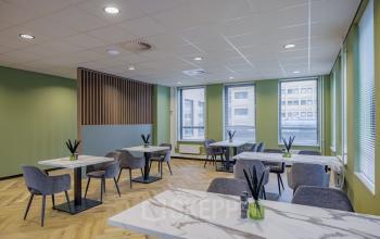 Interieur van kantoorpand aan Hogehilweg 24, Amsterdam Zuid-Oost, met moderne tafels en stoelen, geschikt voor werk of vergaderingen. Ideaal voor kantoorruimte huren met veel daglicht.