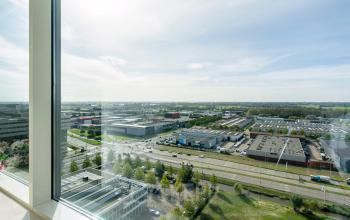 Panoramisch uitzicht vanaf het kantoorpand in Amsterdam Zuid-Oost, gelegen aan De Entree 230-266, met zicht op bedrijventerreinen en groene omgeving. Ideaal voor bedrijven die kantoorruimte willen huren met inspirerende vergezichten.