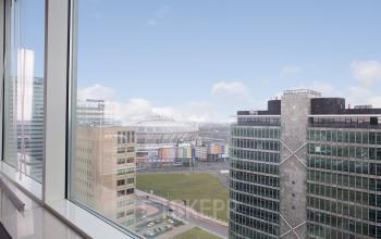 Uitzicht vanuit kantoorpand op De Entree 230-266 in Amsterdam Zuid-Oost, met zicht op naastgelegen gebouwen en een stadion.