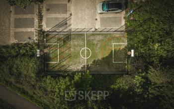 Bovenaanzicht van een sportveld naast een parkeerterrein bij het kantoorpand op Luttenbergweg 8 in Amsterdam Zuid-Oost.