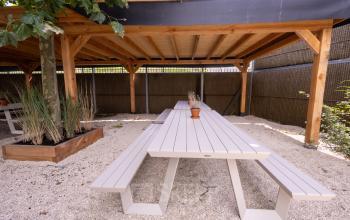 Overdekte buitenruimte met picknicktafels bij kantoorpand op Luttenbergweg 8 in Amsterdam Zuid-Oost voor kantoorruimte huren.