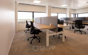 Heldere kantoorruimte aan de Luttenbergweg 8 in Amsterdam Zuid-Oost, geschikt voor huur. Deze open werkvloer heeft voldoende daglicht, moderne bureaus en comfortabele stoelen, ideaal voor diverse zakelijke activiteiten.