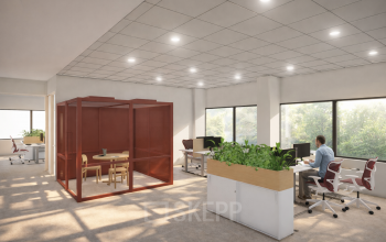 Kantoorruimte te huur in Amsterdam Zuid-Oost op Luttenbergweg 8 met moderne werkplekken en glazen vergaderruimte. Een persoon werkt aan een bureau in een lichte, groene omgeving.