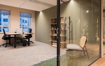 Moderne kantoorruimte huren bij Hullenbergweg 109-135, Amsterdam Zuid-Oost, met glazen wanden, werkplekken en boekenkasten.