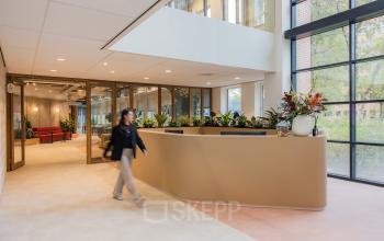 Moderne entree van kantoorpand Hullenbergweg 109-135 in Amsterdam Zuid-Oost, met stijlvolle planten en een receptiebalie. Kantoorruimte huren hier biedt veel potentie.