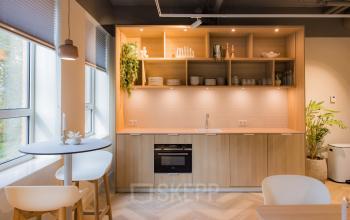 Modern gemeubileerde pantry in een kantoor op Hullenbergweg 109-135, Amsterdam Zuid-Oost, beschikbaar voor kantoorruimte huren. Voorzien van een stijlvol houten interieur en veel natuurlijk lichtinval.