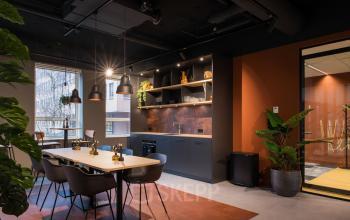 Moderne gemeubileerde kantoorruimte in Amsterdam Zuid-Oost, met een stijlvolle keukenhoek en houten tafels voor vergaderingen. Veel natuurlijk licht en industriële accenten. Kantoorruimte huren op Hullenbergweg 109-135.