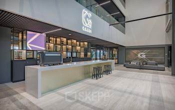 Moderne receptieruimte in een kantoorpand op Herikerbergweg 290, Amsterdam Zuid-Oost, met een stijlvolle balie en comfortabele zitplaatsen.