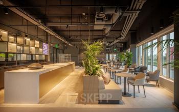 Moderne, ruime kantoorlounge aan de Herikerbergweg 290 in Amsterdam Zuid-Oost met comfortabele zitplekken en grote ramen voor natuurlijk licht, ideaal voor kantoorruimte huren.