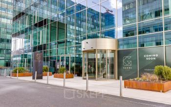 Ingang van het kantoorpand op Herikerbergweg 290, Amsterdam Zuid-Oost, met glazen gevel en moderne uitstraling. Perfect voor kantoorruimte huren op een goed bereikbare locatie.