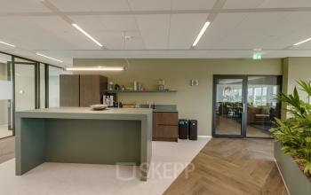 Modern gemeubileerde pantry in een kantoorpand op Herikerbergweg 290, Amsterdam Zuid-Oost. Ruimte voor koffie en snacks, met toegang tot andere kantoorruimten. Geschikt voor huur.