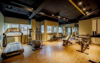 Kantoorruimte huren op Hogehilweg 8 in Amsterdam Zuid-Oost met een fitnessruimte, voorzien van loopbanden, gewichten en fitnessapparaten.