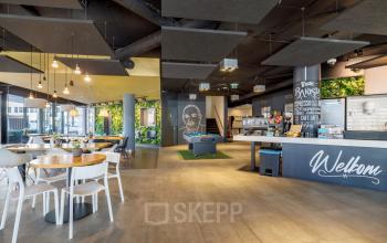 Zakelijke activiteit in het kantoorpand op Hogehilweg 8, Amsterdam Zuid-Oost: informele lounge met zithoeken, biljarttafel en koffiebar.