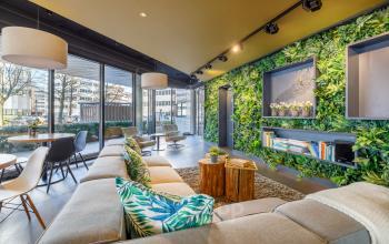 Modern ingerichte lounge in kantoorpand Hogehilweg 8, Amsterdam Zuid-Oost met veel groen en comfortabele zitplaatsen.