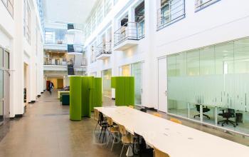 Ruime kantoorruimte in een open vloerplan te huur in Amsterdam Zuid-Oost, Laarderhoogtweg 25. Het interieur is modern met een lange tafel en stoelen, geschikt voor vergaderingen en samenwerkingen.