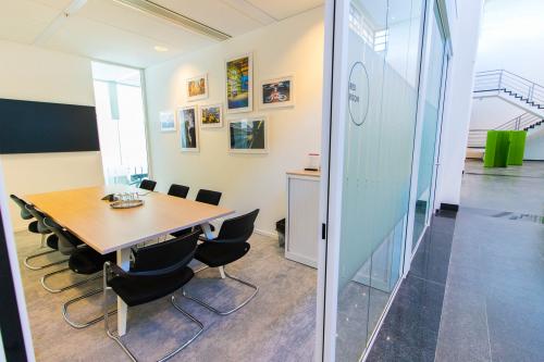 Moderne vergaderruimte in een kantoorpand op Laarderhoogtweg 25, Amsterdam Zuid-Oost, met een lange tafel en stoelen, omringd door kunstwerken aan de muur.
