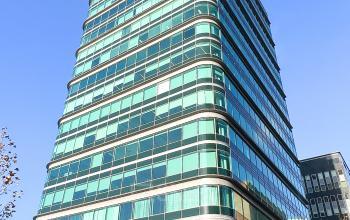 Het exterieur van een modern kantoorpand aan De Entree 230 in Amsterdam Zuid-Oost, met veel glas en een opvallend ontwerp.