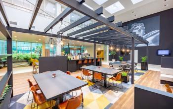 Moderne en ruime werkplekken in een kantoorpand op Herikerbergweg 1-35, Amsterdam Zuid-Oost, met veel lichtinval, stijlvolle meubels, en een uitnodigende sfeer.