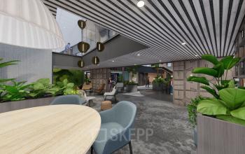 Binnenruimte van kantoor op Jachthavenweg 109-A in Amsterdam Zuidas, met moderne inrichting, planten, tafels en stoelen, meerdere niveaus zichtbaar, enkele mensen werkend of in gesprek.