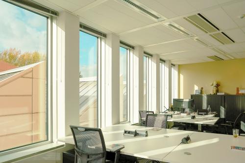 Kantoorpand Jachthavenweg 109-A in Amsterdam Zuidas met werkplekken, bureaus en stoelen, veel natuurlijke lichtinval door grote ramen.