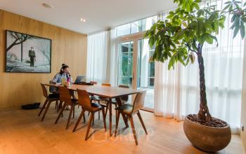 Kantoorruimte huren op Barbara Strozzilaan 101-201 in Amsterdam Zuidas met houten vloer, grote tafel, plant en kunst aan de muur.