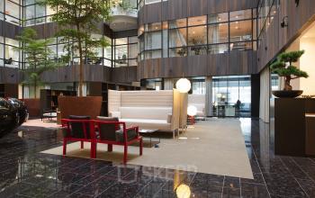 Modern ingerichte lobby in kantoorpand aan Strawinskylaan 3051, met stijlvol meubilair en een open uitstraling, geschikt om kantoorruimte te huren.