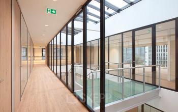 Modern kantoorpand aan De Boelelaan 30 in Amsterdam Zuidas met glazen wanden en houten vloeren. Veel natuurlijk licht maakt dit een aangename ruimte om te huren.