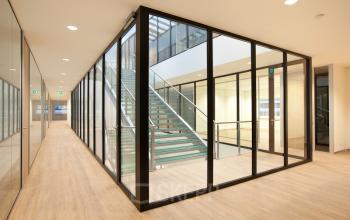 Glazen-wand kantoorpand met houten vloer en trap bij De Boelelaan 30, Amsterdam Zuidas. Ideaal voor kantoorruimte huren.