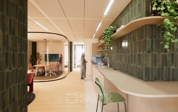 Modern kantoorpand op Beethovenstraat 503 in Amsterdam Zuidas met stijlvolle inrichting, groene accenten en een gemeubileerde pantry. Personen zijn actief bezig met werk gerelateerde activiteiten, ideaal voor kantoorruimte huren.