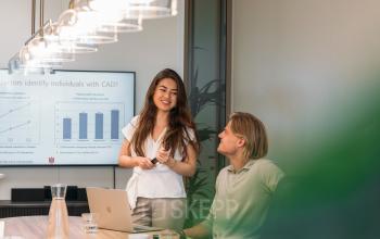 Moderne kantoorruimte te huur op Beethovenstraat 503 in Amsterdam Zuidas, met collega’s in overleg aan een vergadertafel.