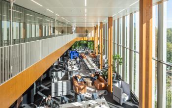 Moderne kantoorruimte huren in een ruim opgezet kantoorpand op Fred. Roeskestraat 115, Amsterdam Zuidas, met grote ramen, comfortabele zitplekken en werkende mensen aan tafels.