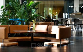 Stijlvolle kantoorruimte huren op Fred. Roeskestraat 115, Amsterdam Zuidas met modern interieur, comfortabele zitplaatsen en veel groen.