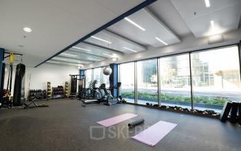 Kantoorruimte huren aan de Fred. Roeskestraat 115 in Amsterdam Zuidas. Moderne fitnessruimte met diverse apparatuur voor gebruik in het kantoorpand.