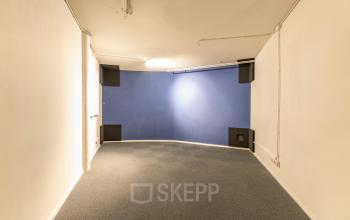 Lege kantoorruimte te huur op De Boelelaan 1110 in Amsterdam Zuidas, met blauw geverfde muur en vloerbedekking, geschikt voor diverse kantoordoeleinden.