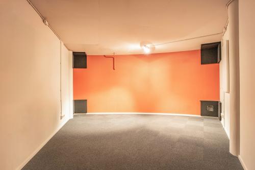 Een kantoorpand met een oranje muur en grijze vloerbedekking op De Boelelaan 1110, Amsterdam Zuidas. Ideaal voor wie kantoorruimte wil huren in de zakelijke kern van Amsterdam.