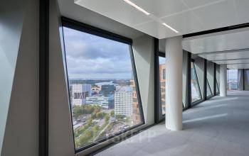Leeg kantoorpand met grote ramen en uitzicht op Amsterdam Zuidas. Perfecte locatie voor kantoorruimte huren met natuurlijk licht en een panoramisch uitzicht.