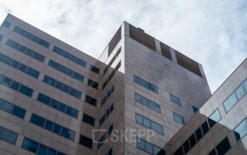 Uitzicht op het kantoorpand aan de Barbara Strozzilaan 101 in Amsterdam Zuidas. Moderne architectuur met grote ramen, ideaal om een kantoorruimte te huren midden in het dynamische zakelijke hart.