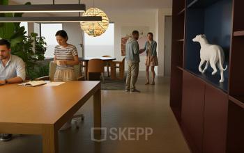 Ruime en moderne kantoorruimte op Barbara Strozzilaan 101 101 in Amsterdam Zuidas, met houten tafels en zakelijke professionals die samenwerken. Planten en decoratieve elementen creëren een aangename werksfeer.