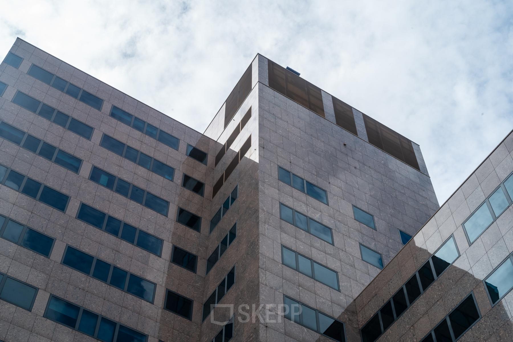 Uitzicht op het kantoorpand aan de Barbara Strozzilaan 101 in Amsterdam Zuidas. Moderne architectuur met grote ramen, ideaal om een kantoorruimte te huren midden in het dynamische zakelijke hart.