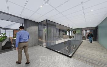 Moderne kantoorruimte aan Jachthavenweg 109, Amsterdam Zuidas met glazen wanden en houten vloeren. Personen voeren zakelijke gesprekken en lopen door de gang. Kantoorruimte huren op deze locatie biedt zakelijke mogelijkheden.
