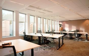 Heldere kantoorruimte aan Jachthavenweg 109 in Amsterdam Zuidas, met ruime bureaus en ergonomische stoelen om te huren als kantoor. Grote ramen zorgen voor veel natuurlijk licht in dit kantoorpand.