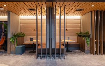 Moderne kantoorruimte huren aan Jachthavenweg 109 in Amsterdam Zuidas met stijlvolle zitplekjes en houten elementen.